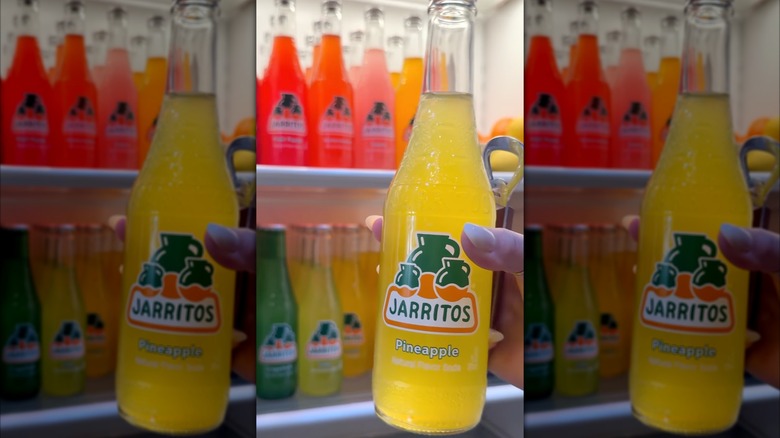 Close-up of Jarritos Pineapple soda in a woman's hand.