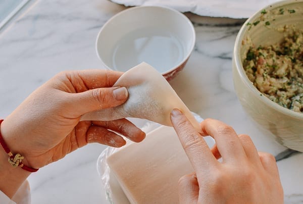 Dabbing corner of wonton wrapper with water, thewoksoflife.com