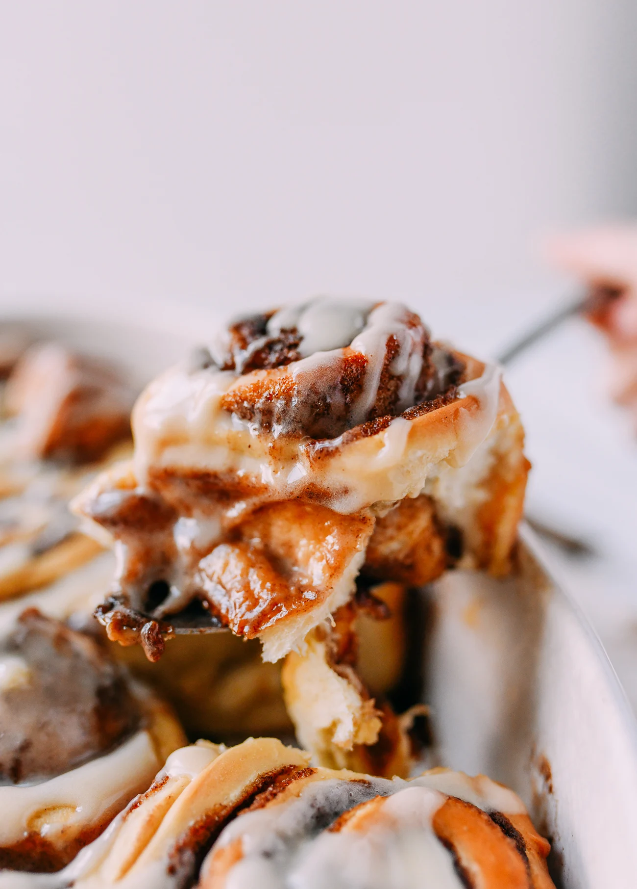 Removing fluffy cinnamon roll from baking dish