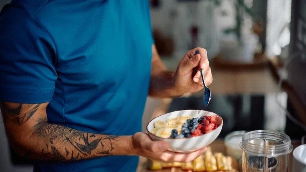 Close up of man having a healthy breakfast in the kitchen.