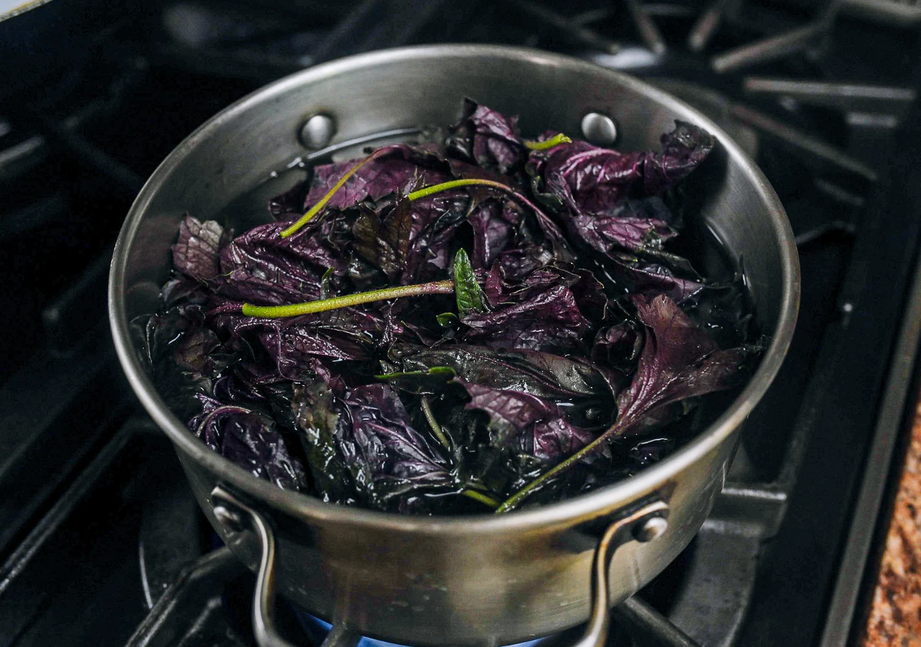 simmering red shiso leaves in water