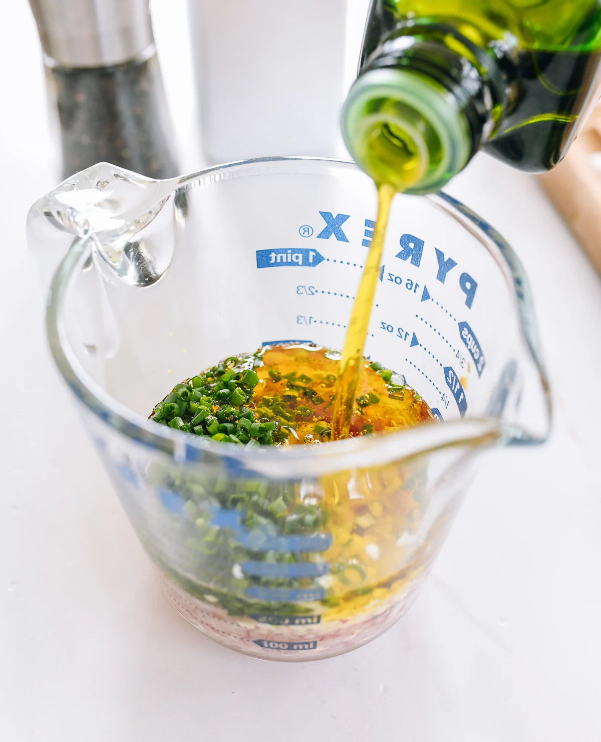 pouring olive oil into measuring cup