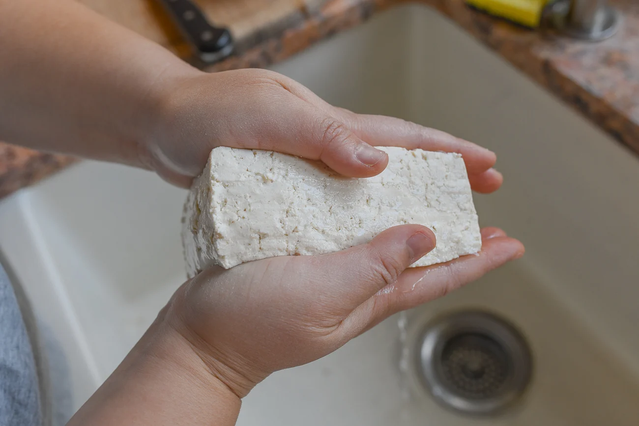 squeezing tofu between hands