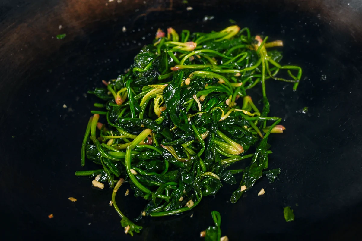 stir-fry spinach in wok