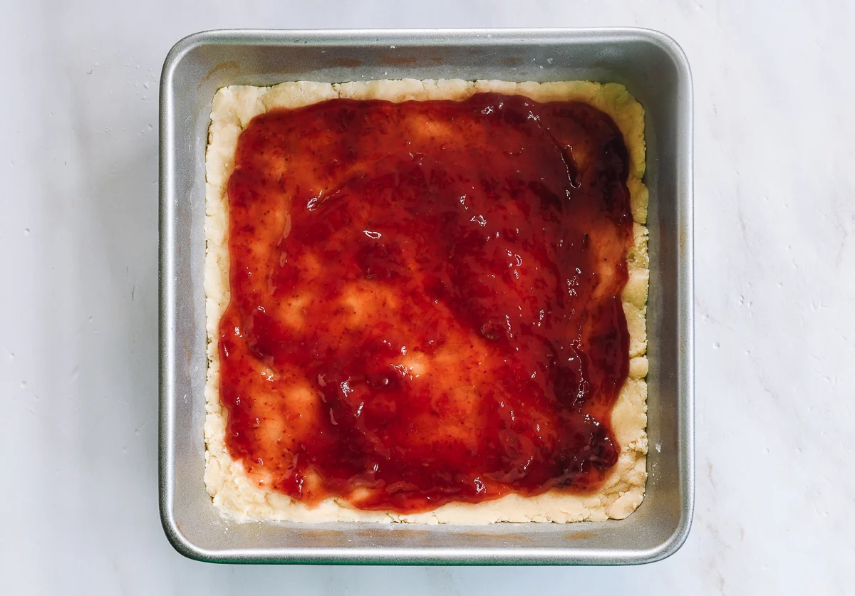 strawberry jam spread onto dough with border
