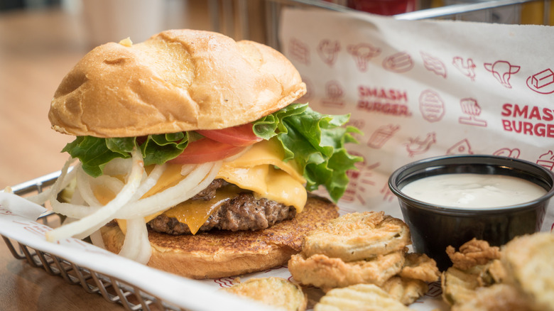 Smashburger burger beside fried pickles on tray