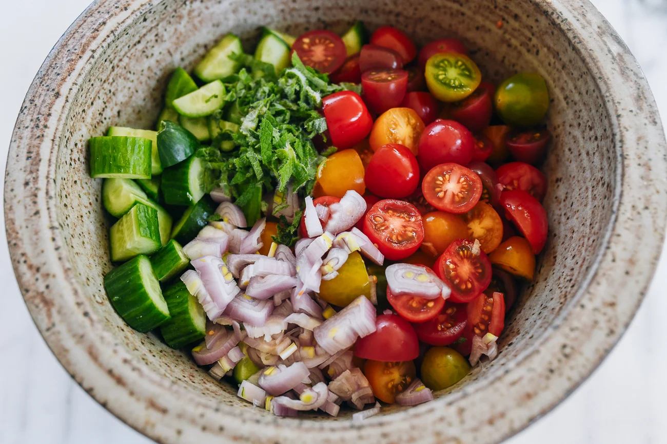 ingredients for cucumber tomato salad in mixing bowl
