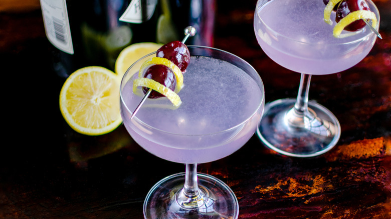 Aviation Gin Cocktails Garnished with Luxardo Cherries: Gin cocktails made with creme de violette and served in coupe glasses