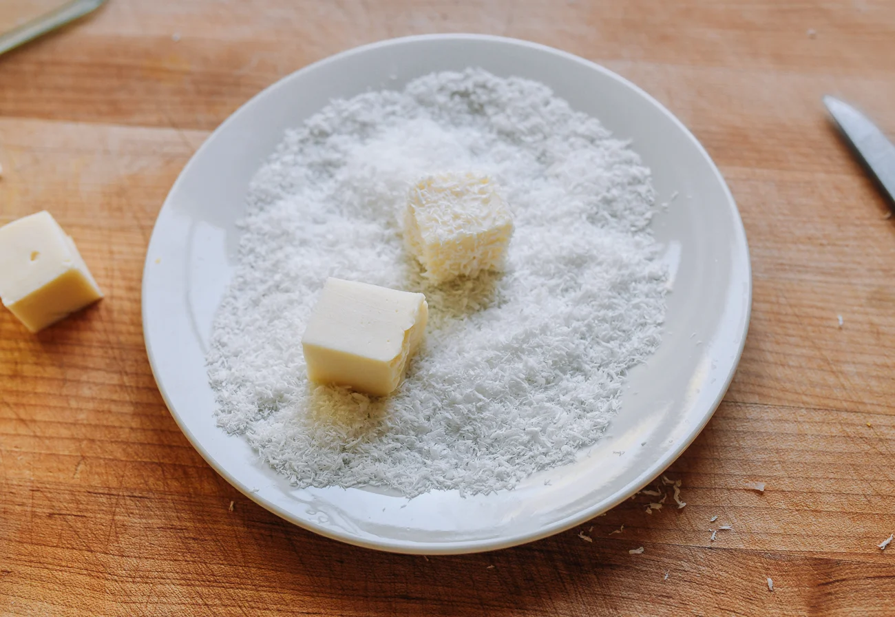 coating milk pudding cubes in coconut