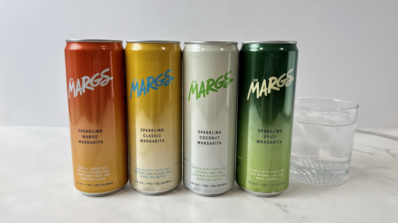 cans of Margs tequila cocktails and glass with cocktail