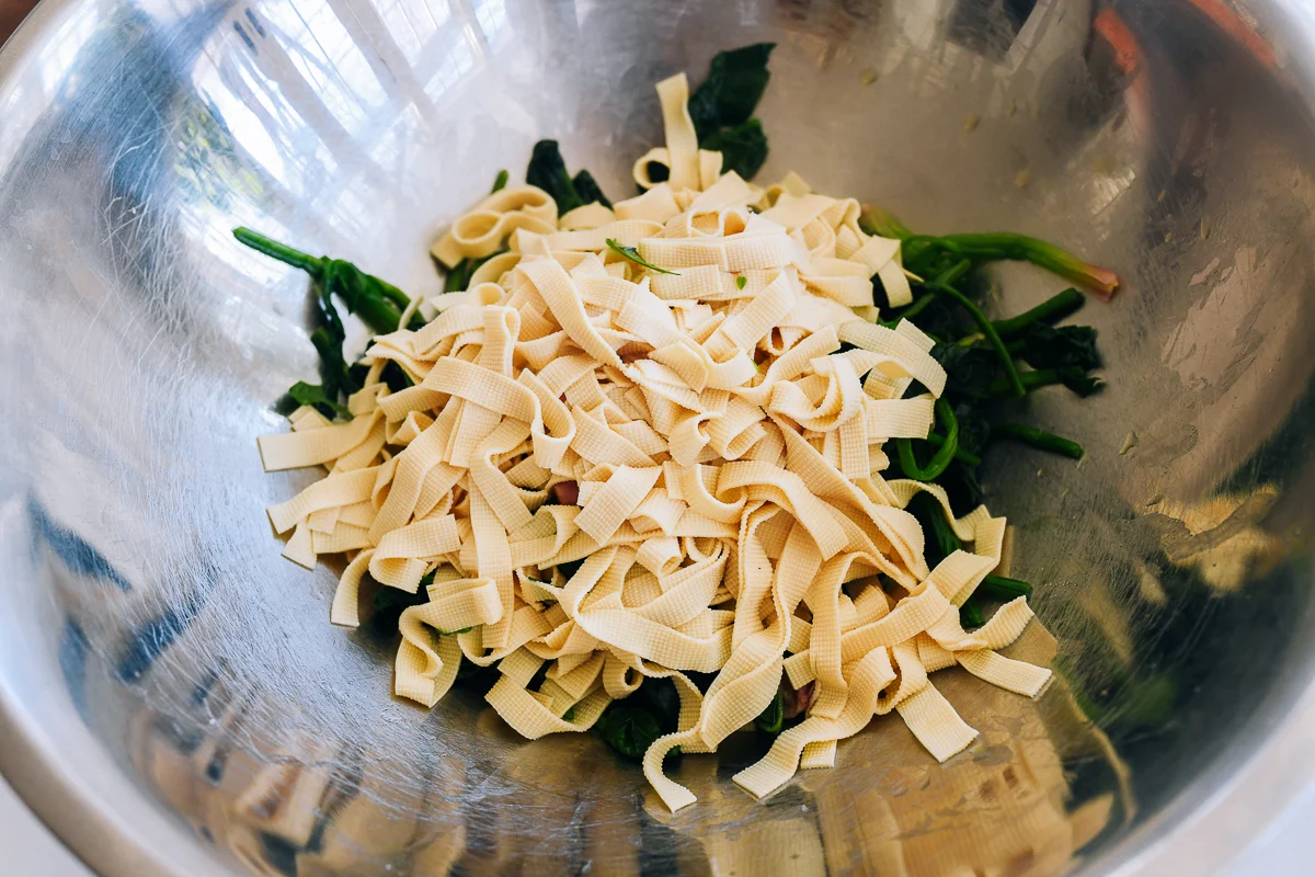 blanched spinach and tofu skin in metal bowl