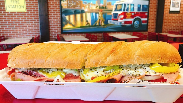 Italian sub in container with Firehouse Subs interior in background