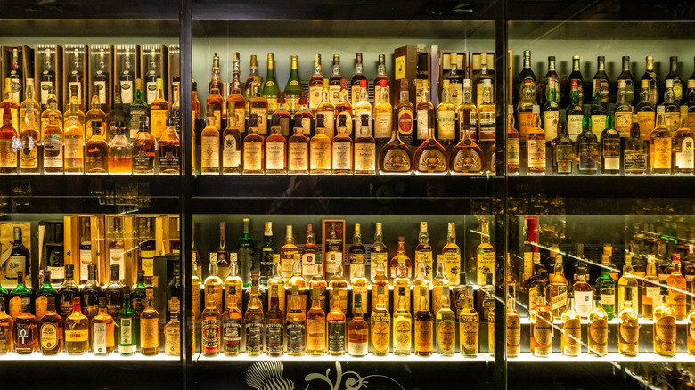 an enormous collection of vintage Scotch whiskies in a glass cabinet