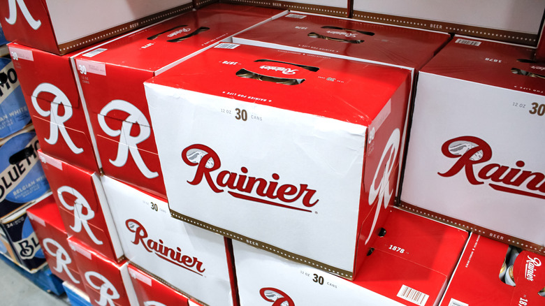 A large stack of 30-can crates of Rainier beer shown in a liquor store