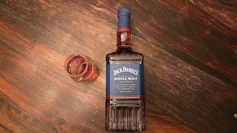 Bottle of Jack Daniel's American Single Malt on its side with Glencairn glass