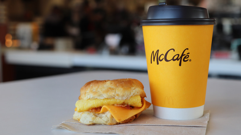 A biscuit sandwich next to a cup of McCafe coffee