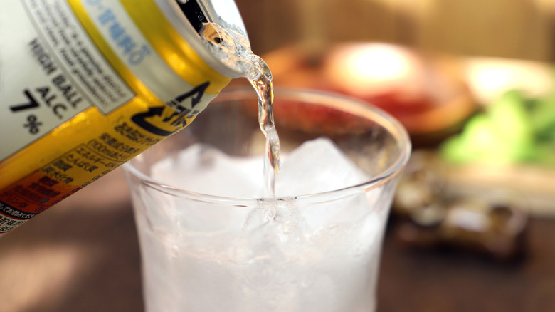 Canned cocktail being poured into clear glass