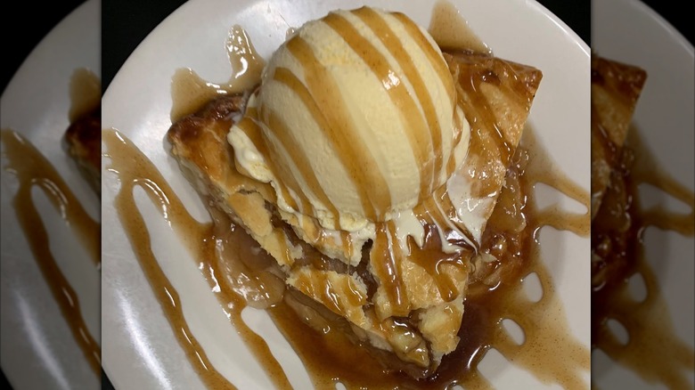 Apple pie from Texas Roadhouse with caramel sauce and ice cream on top in a white bowl