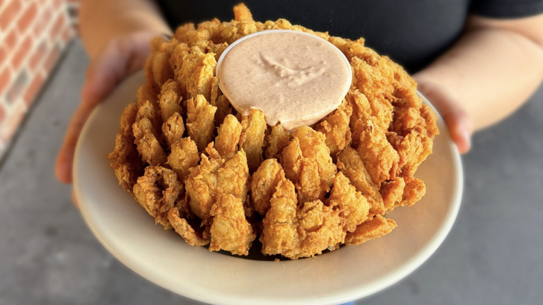 Cactus blossom from Texas Roadhouse with dip in the middle on a white plate