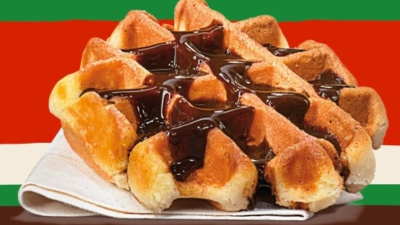 A round Belgian waffle drizzled with chocolate sauce