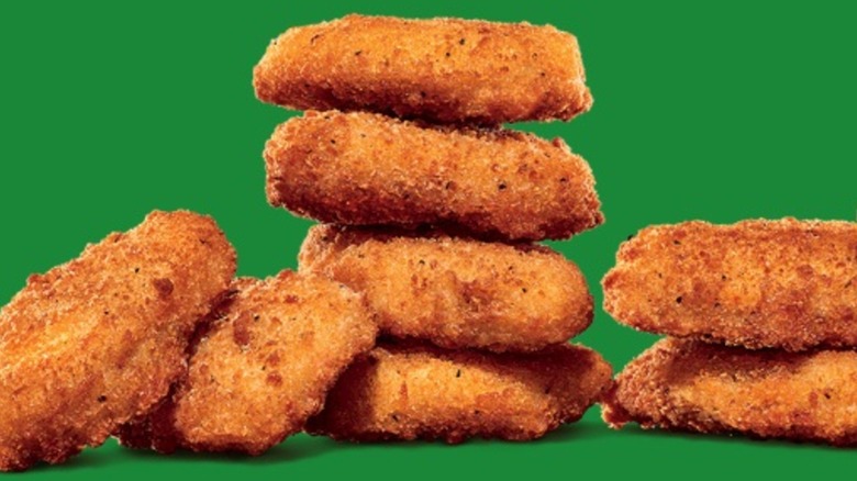 Stacks of plant-based nuggets on a green background