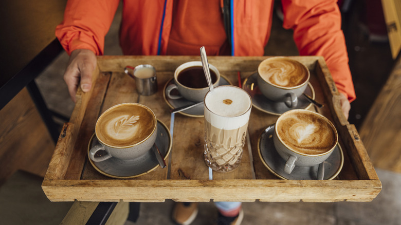 Person holding tray of fall coffee beverages