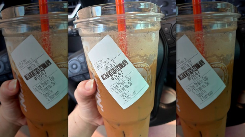 customer holding Dunkin' drink order