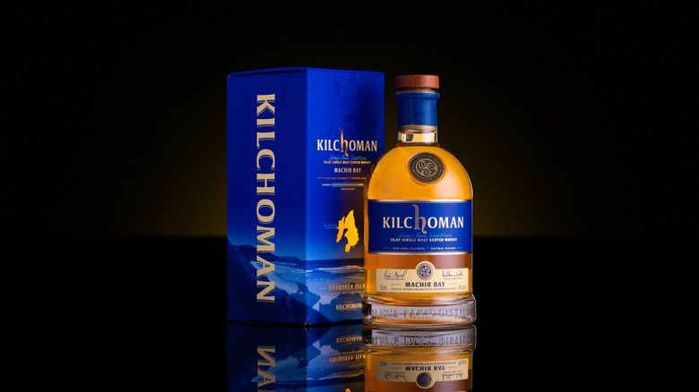 A stylized product shot of a bottle of Kilchoman Machir Bay in front of a plain black background