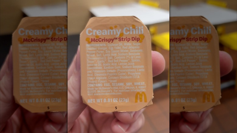 hand holding a packet of McDonald's Creamy Chili McCrispy Strip Dip
