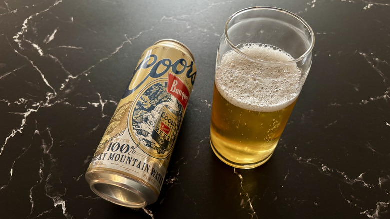 Coors Banquet can next to glass of beer