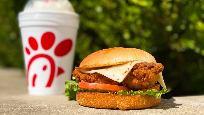 The Spicy Deluxe Chicken sandwich and a beverage from Chick-fil-A on a table