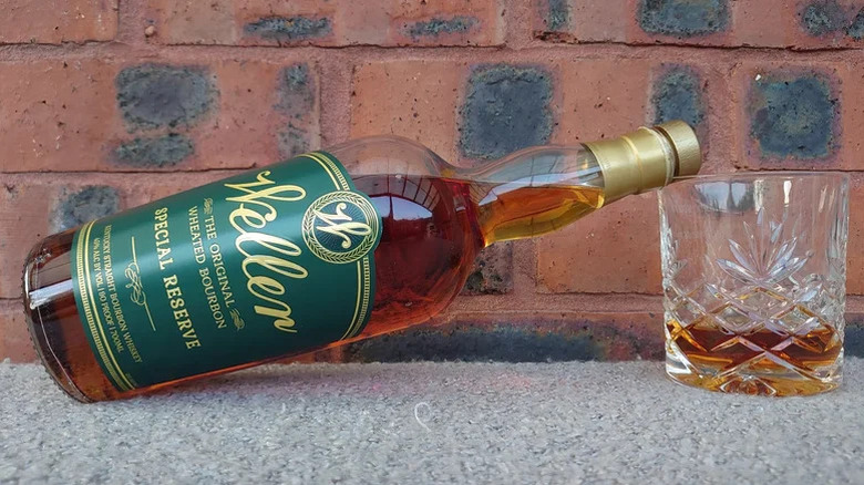 A bottle of Weller Special Reserve balanced on the rim of a filled glass