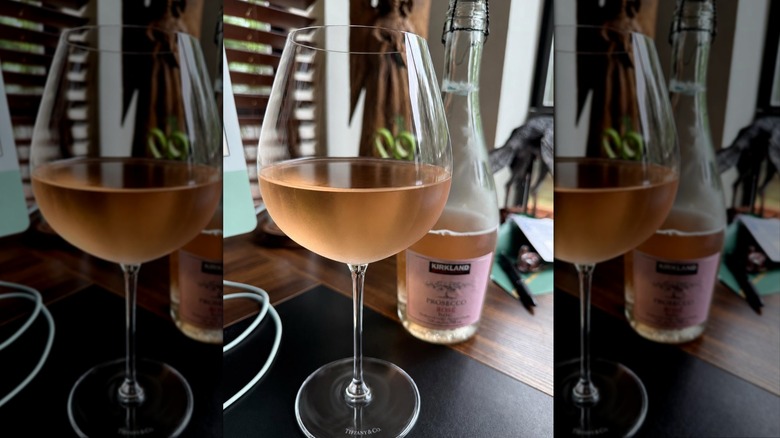 Glass of Kirkland Signature Prosecco Rosé with bottle in background