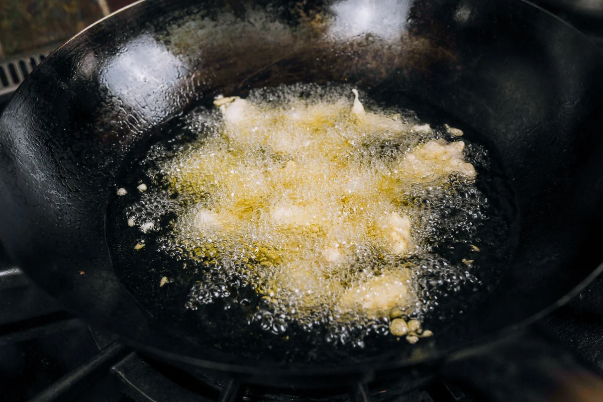 chicken pieces in wok of oil for sesame chicken