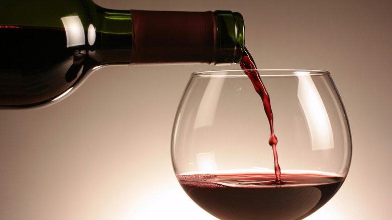 Dark red wine being poured into a wine glass
