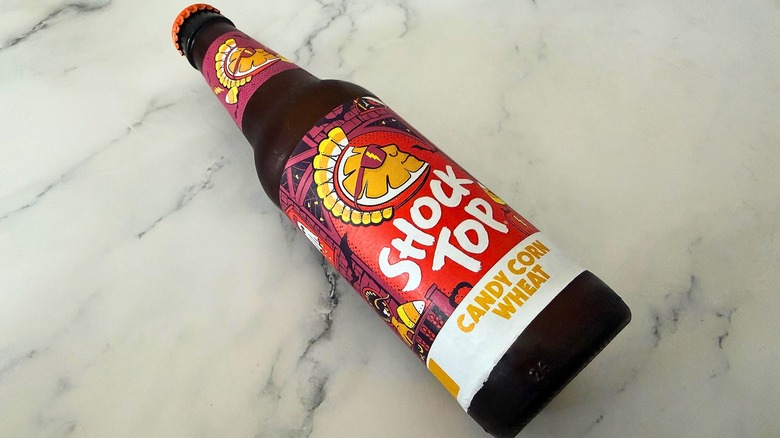 Bottle of Shock Top Candy Corn Wheat Ale laying down on marble surface