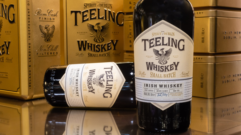 A bottle of Teeling Small Batch, with another bottle laid on its side, in front of their packaging boxes