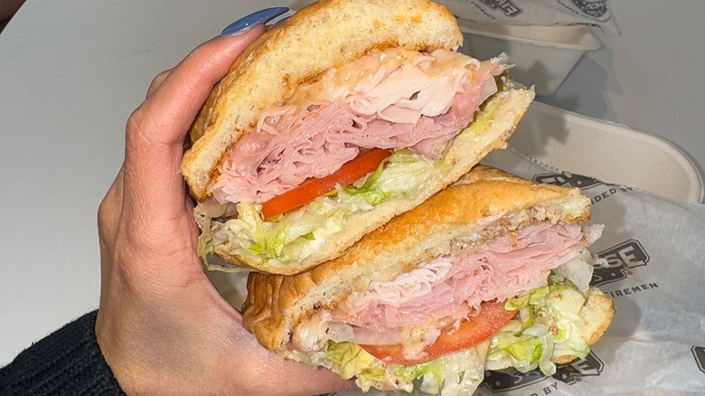 Hand holding Fully Loaded Hook & Ladder Firehouse Sub over paper