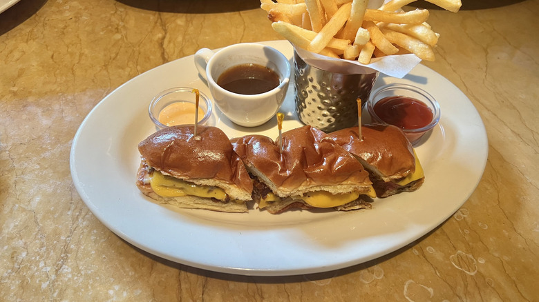Cheesecake Factory French Dip Cheeseburger and fries on plate.