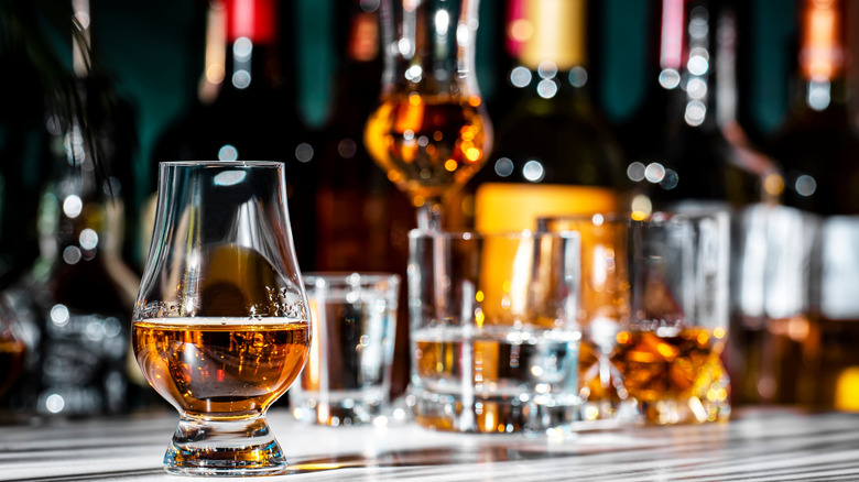 A gilled Glencairn glass shown on a table with other blurred glasses shown behind