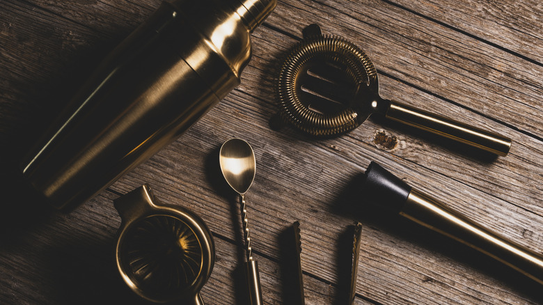 A top down shot of a collection of simple bar tools on a wooden surface