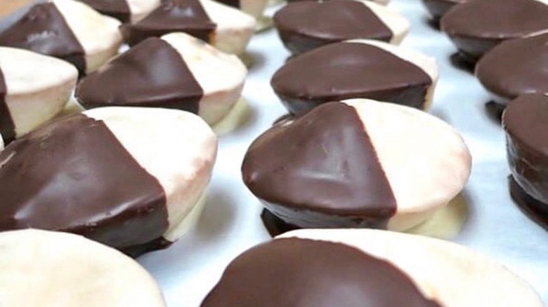 Baking tray full of domed black and white cookies