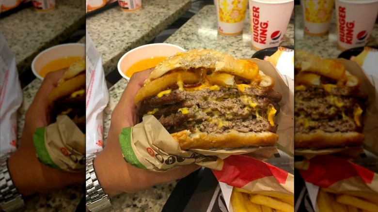 Hand holding burger from Burger King
