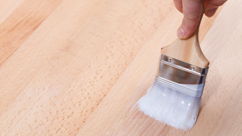 Hand varnishing a wooden kitchen counter.