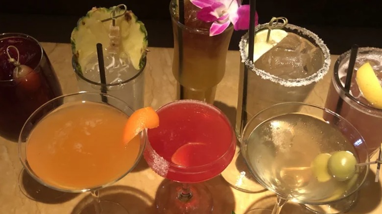Four P.F. Chang's cocktails on a table and orange chicken in the forefront