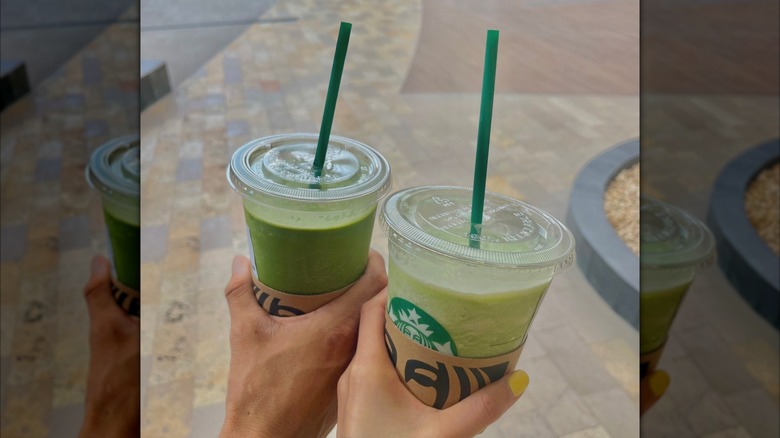 Two people holding Starbucks Matcha Latte drinks