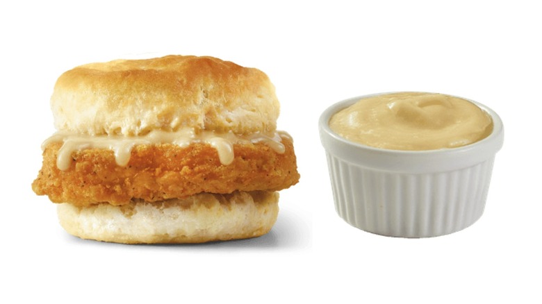 Chicken biscuit next to a small pot of Swiss cheese sauce