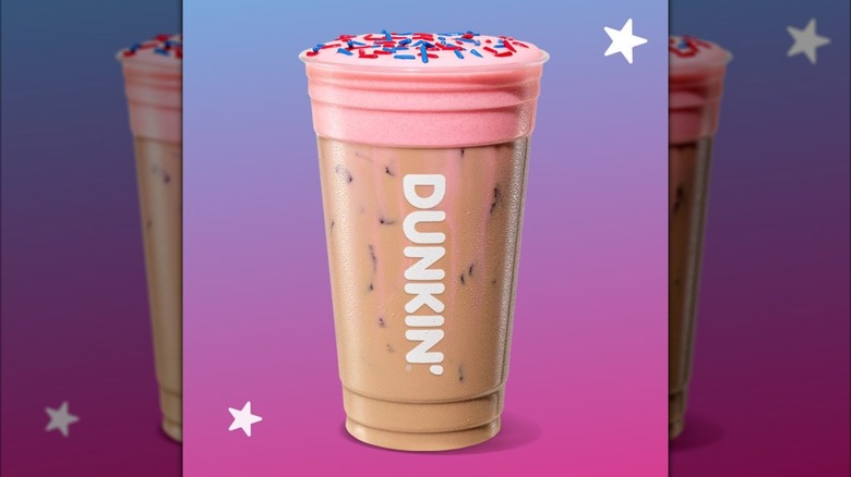 Dunkin' Strawberry Sparkler Cloud Latte drink in cup against pink and blue gradient background