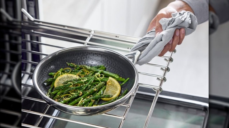 A person removing a GreenPan nonstick frypan of vegetables from the oven