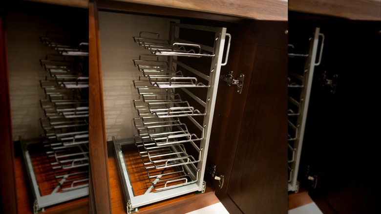View of a vertical pan storage rack in a kitchen cabinet.